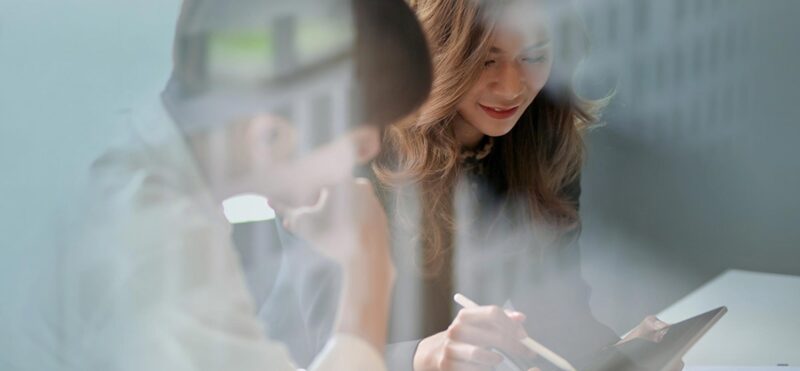 Two ladies discussing strategy over a tablet