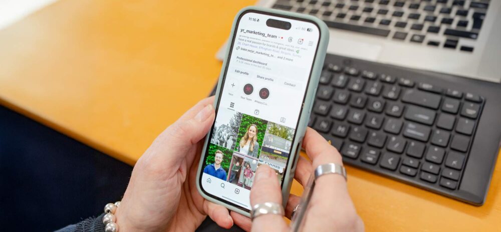 Marketing agency reviewing Instagram profile and social media content on a smartphone