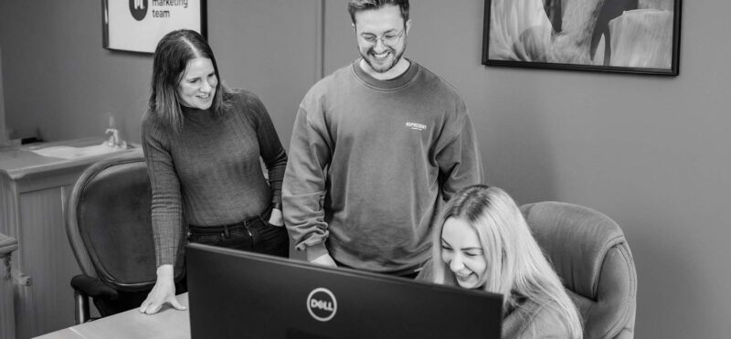 Marketing agency team reviewing work together on screen during an informal collaboration
