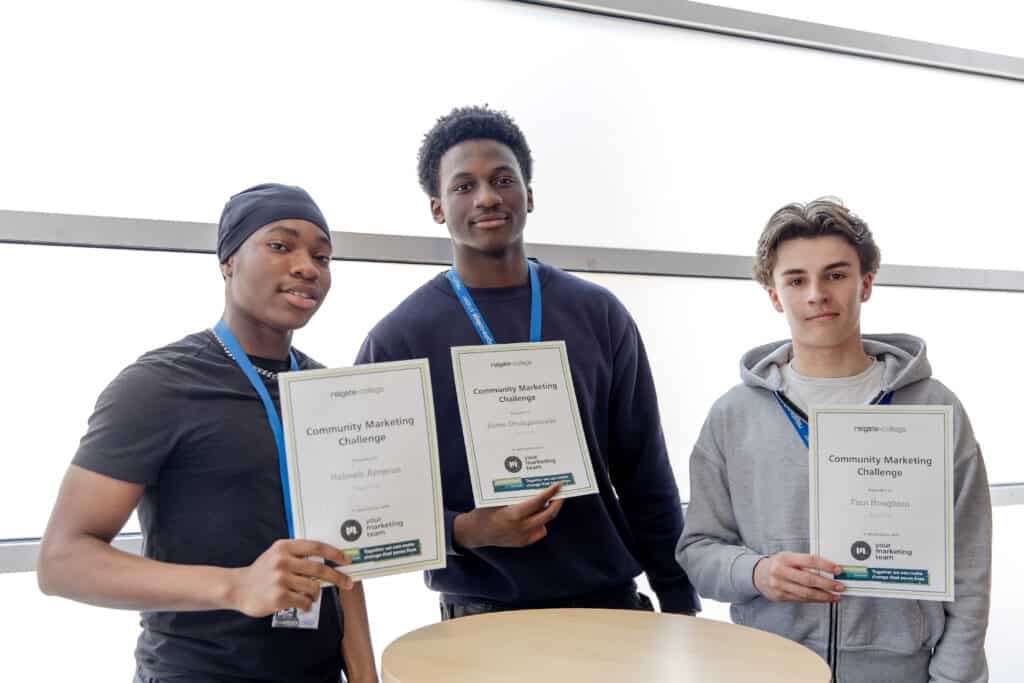 Pictured left to right: Habeeb, Sore and Finn are standing in front of a bright window holding up their certificates as winners as the Community Marketing Challenge in association with Your Marketing Team and The Samaritans East Surrey. 