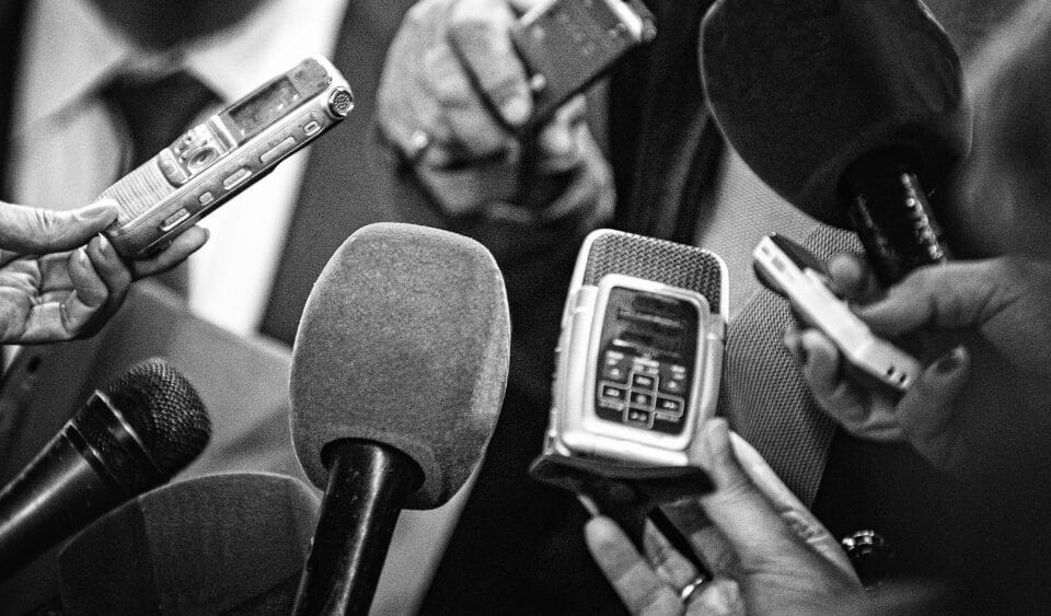 Dos and Donts for using AI for PR from a real PR Consultant. Image shows a black and white photograph of press reporters with microphones and tape recorders.