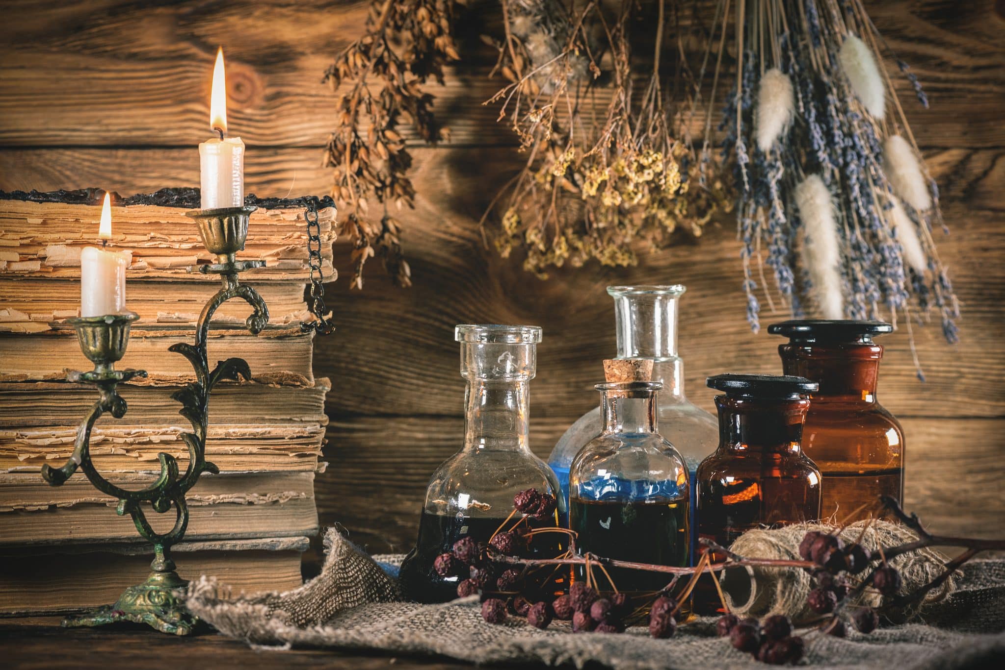 Magic potions and old books on the table close up background.